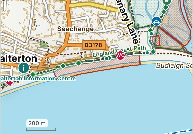 Map of Budleigh Salterton beach: the stretch where dogs are banned 1 May to 30 September is hatched in brick, and the esplanade and grass, where dogs must be on a lead all year, has a dashed brick edge.