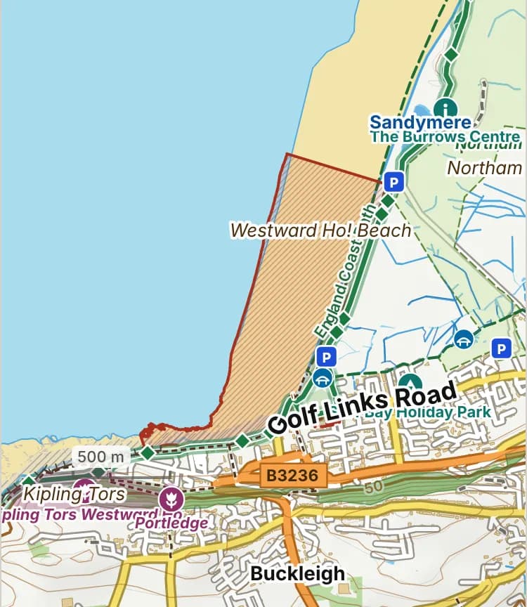 Map of Westward Ho! beach: the stretch where dogs are banned 1 May to 30 September is hatched in brick, and the promenade, where dogs must be on a lead 1 May to 30 September, has a dashed brick edge.