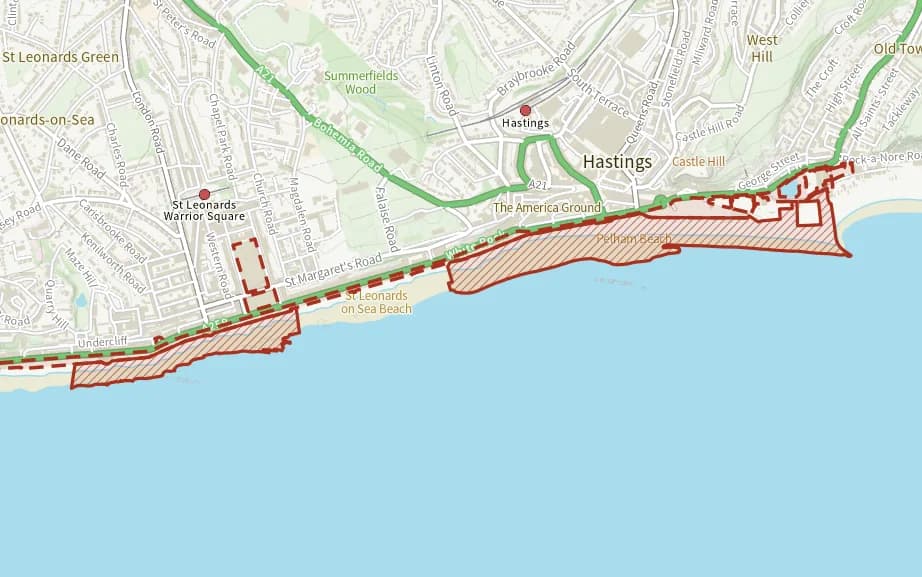 Map of Hastings and St Leonards beach: the stretch where dogs are banned 1 April to 30 September is hatched in brick, and the promenade, stade open space, the grass east of marine court and warrior square gardens, where dogs must be on a lead all year, has a dashed brick edge.
