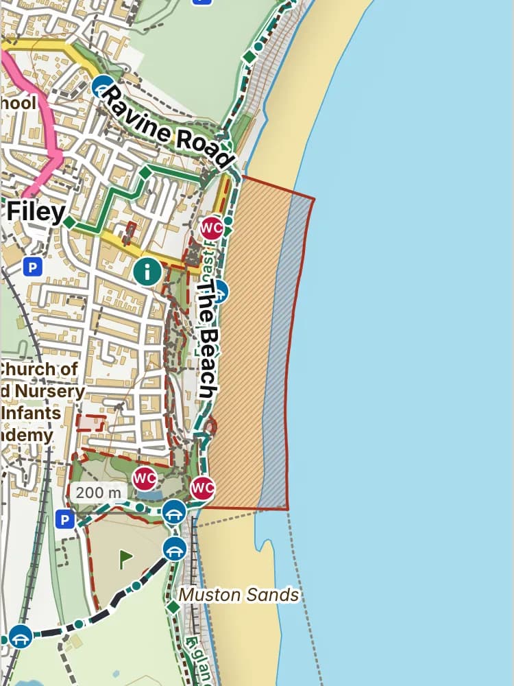 Map of Filey beach: the stretch where dogs are banned 1 May to 30 September is hatched in brick, and the promenade, where dogs must be on a lead all year, has a dashed brick edge. Beaches we have not placed an order on are outlined in grey dots, and say nothing about dogs.
